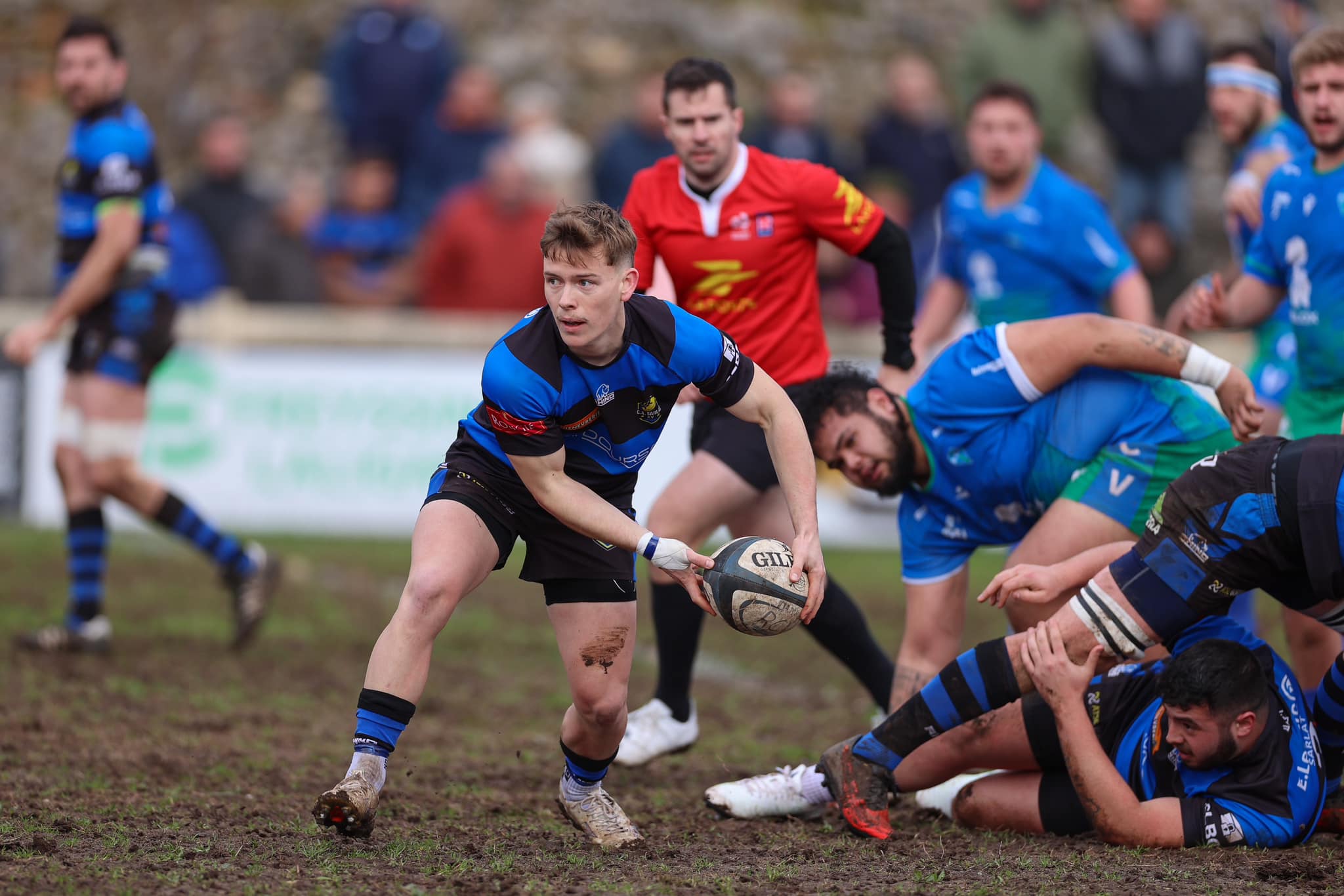 un joueur de rugby de sarlat fait une passe ballon en main